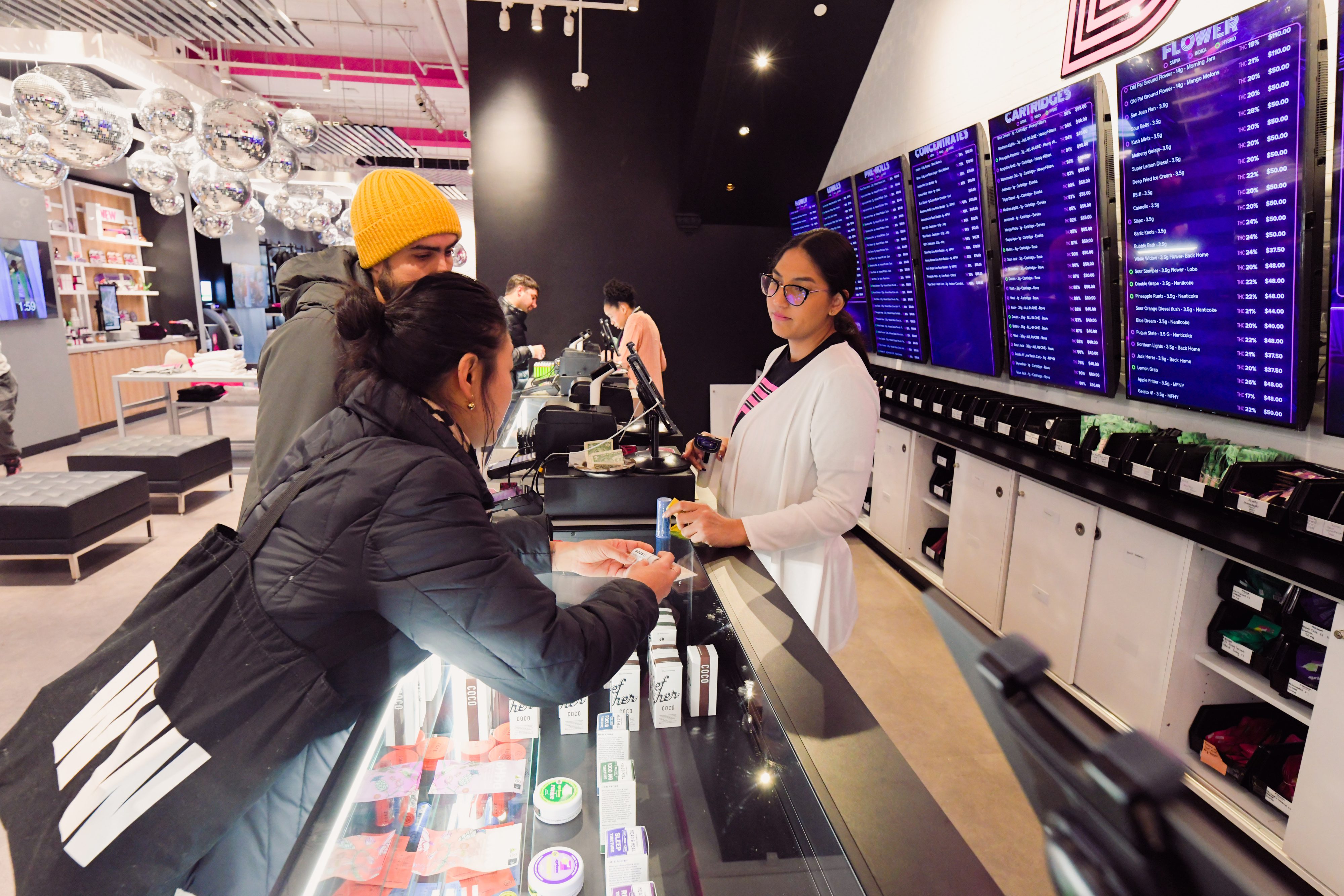 Budtenders showing dispensary customers cannabis products